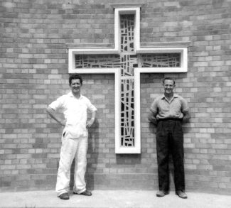 Two of the builders who were employed to finish the church, outside the stained glass cross.