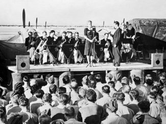 Geraldo and his orchestra, fronted by the singer Dorothy Carless, entertain airmen at an airfield in North Africa, 1943. | This is photograph CM 5442 from the collections of the Imperial War Museums