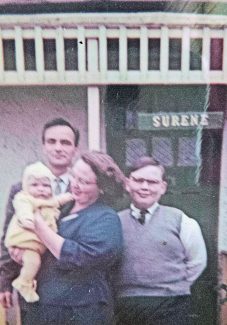 Outside Surene: George Gaines and Irene Gaines holding Andrew Gaines. 13 year old Allan Gaines (the author's husband) stands in the porch | Pamela-Jeanetta Bird Gaines